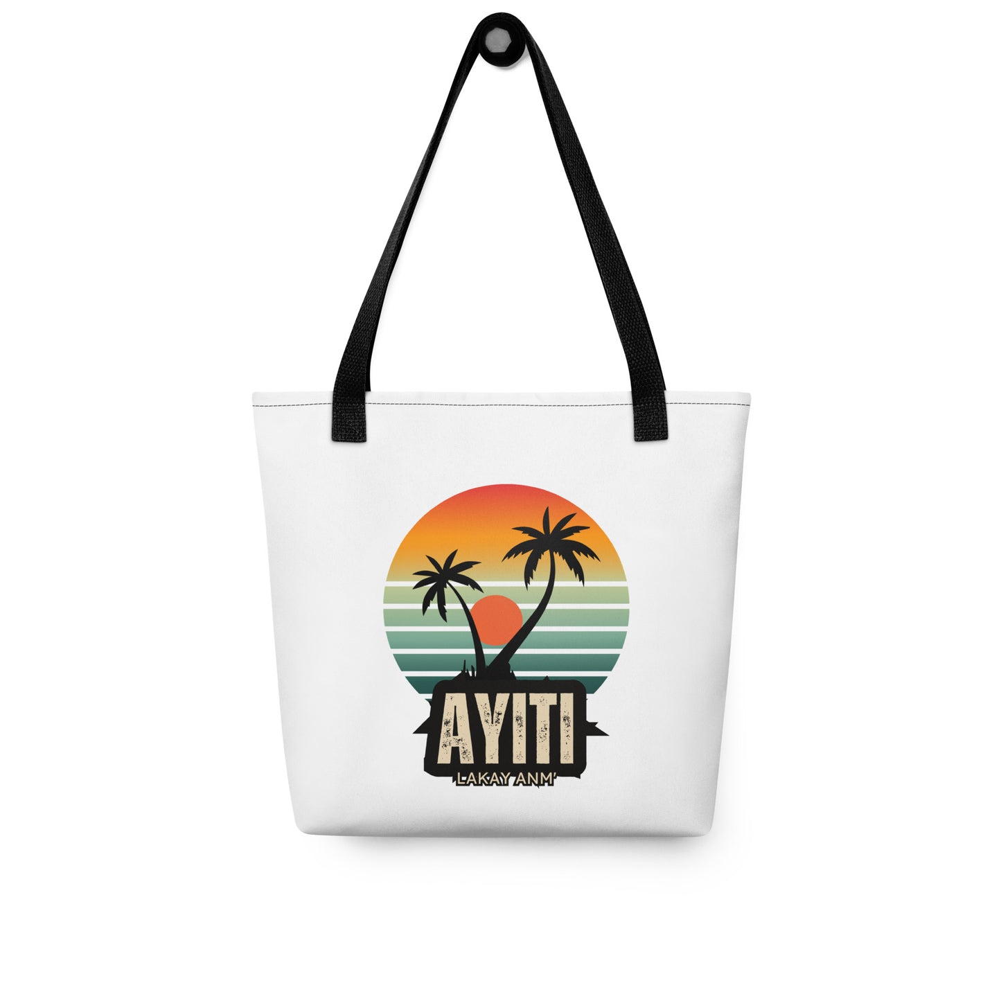 White canvas tote bag with black handles, featuring a circular graphic with an orange and yellow sunset over blue and green stripes, silhouetted by two palm trees. The text 'AYITI' and 'LAKAY ANM'' is below the graphic in a stylized font.
