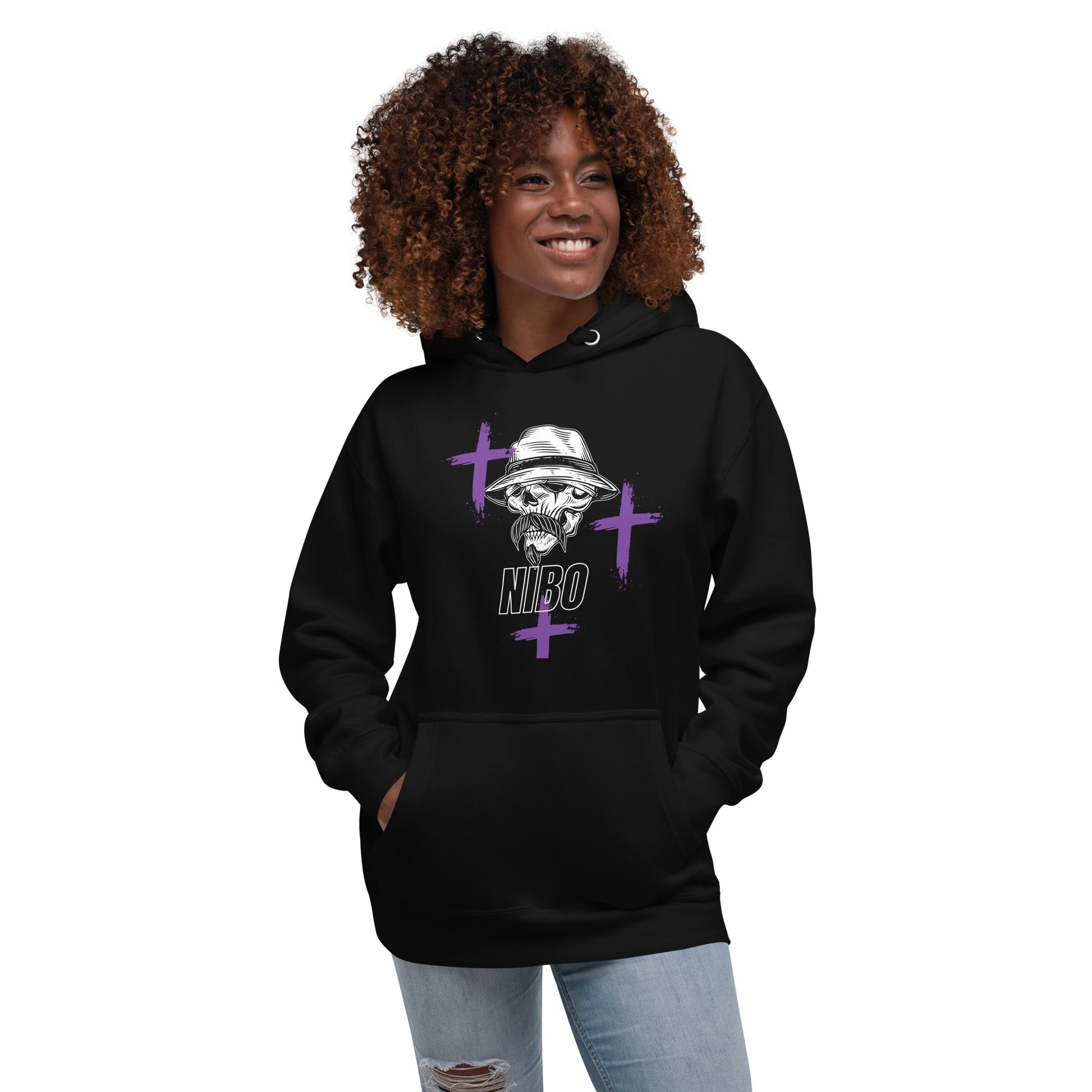 A black female model wearing a pullover hoodie with a stylish red graphic of a stylized skull wearing a fedora hat and a mustache. Purple cross symbols are scattered around the skull, and the text 'NIBO' is written below it. The design is a spiritual nod to Haitian Gede culture.