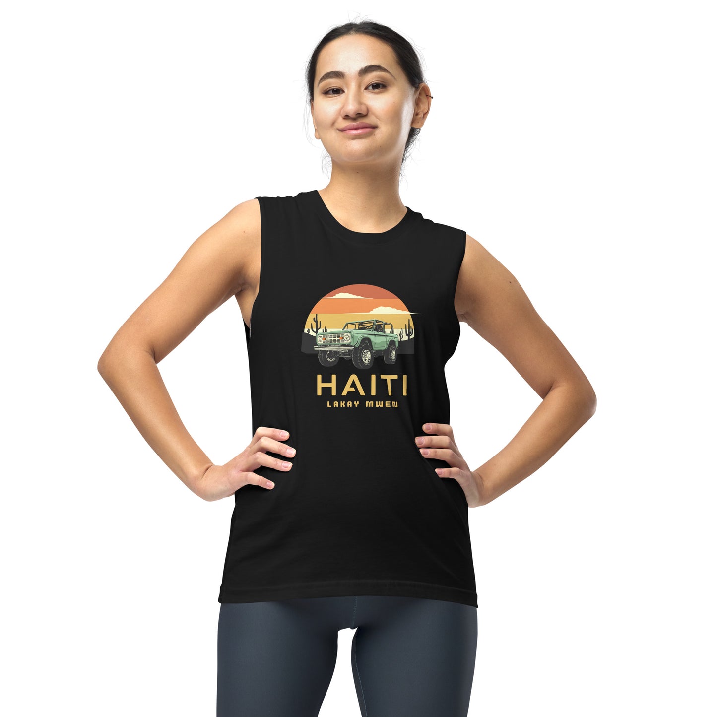 Female model wearing a black Bella+Canvas 'HAITI LAKAY MWEN' unisex muscle tank top (front view) featuring a retro sunset and green vintage Jeep graphic. White background.