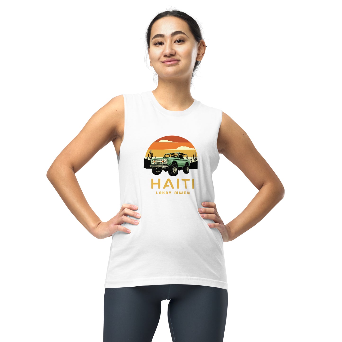 Female model wearing a white Bella+Canvas 'HAITI LAKAY MWEN' unisex muscle tank top (front view) featuring a retro sunset and green vintage Jeep graphic.