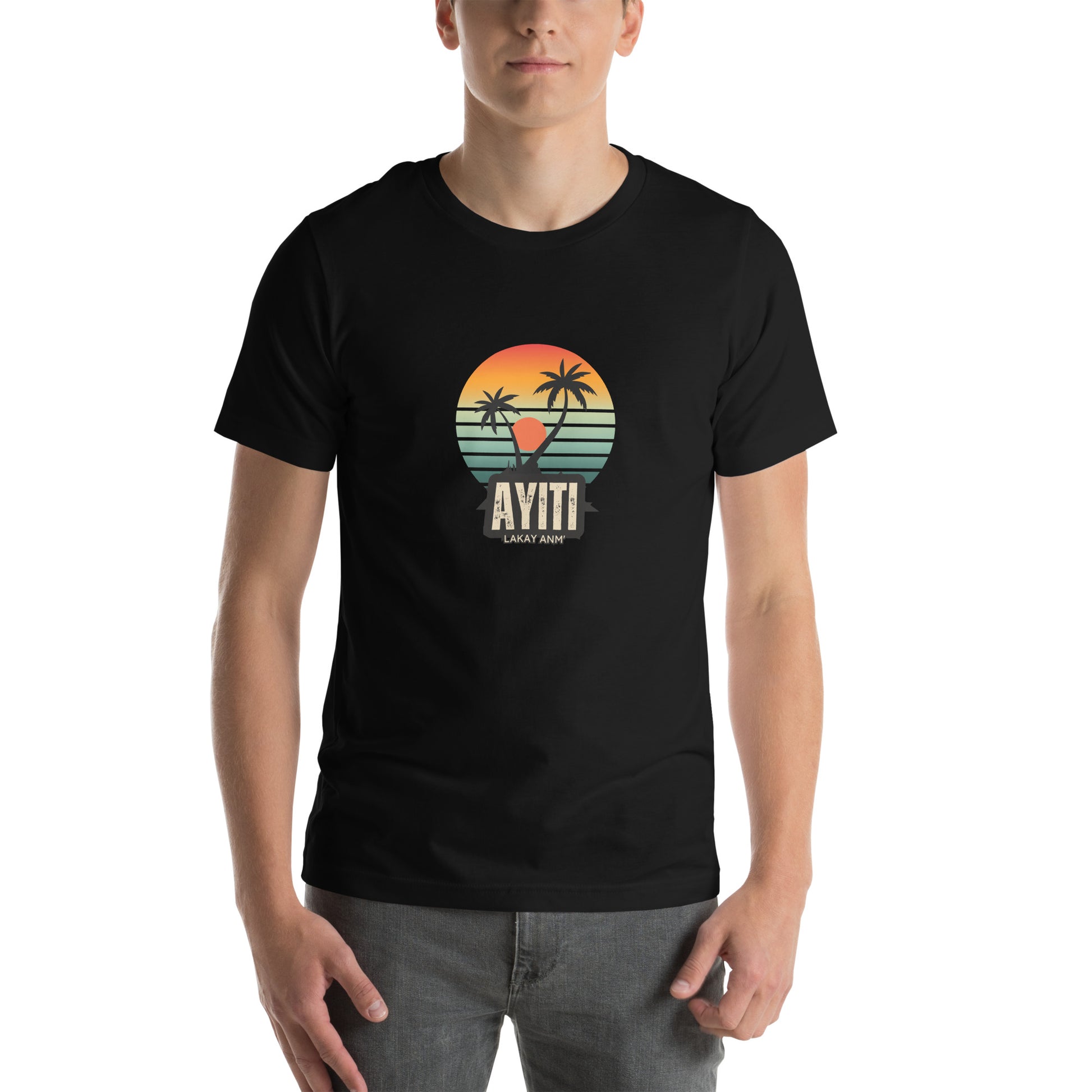 White man wearing a black Bella+Canvas 'Ayiti Lakay Anm'' unisex T-shirt (front view) featuring a vibrant retro sunset graphic with two palm trees silhouetted. White background.