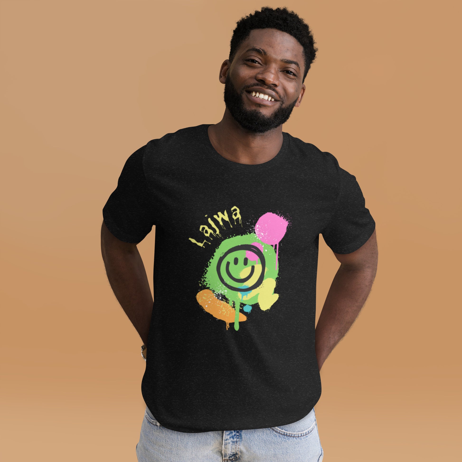Smiling black male model wearing a black Bella+Canvas 'Lajwa' unisex T-shirt (front view) with a colorful dripping paint smiley face graphic in bright pink, green, orange, and yellow.