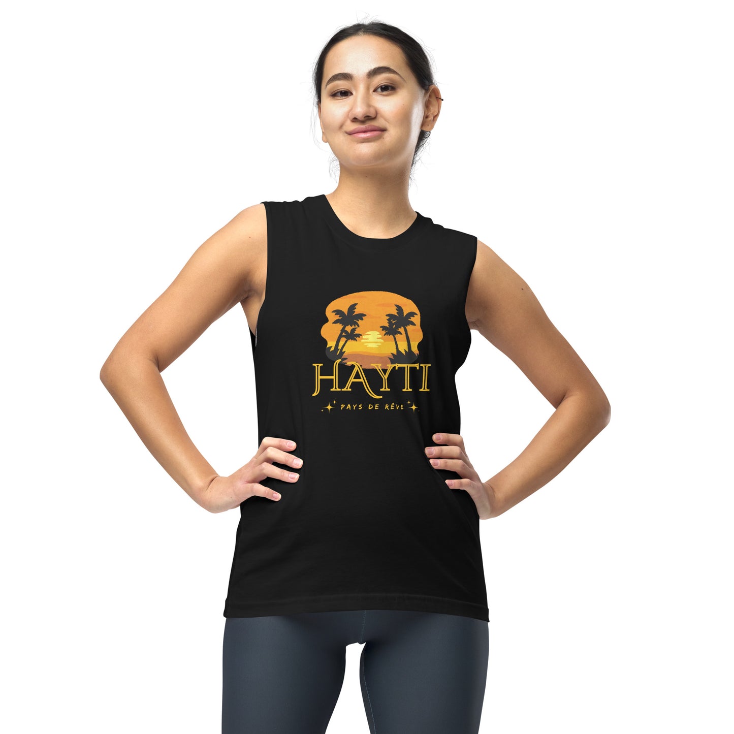 Female model wearing a black Bella+Canvas 'HAYTI PAYS DE RÊVE' unisex muscle tank top (front view) featuring a golden hour sunset graphic with palm trees and twinkling stars.