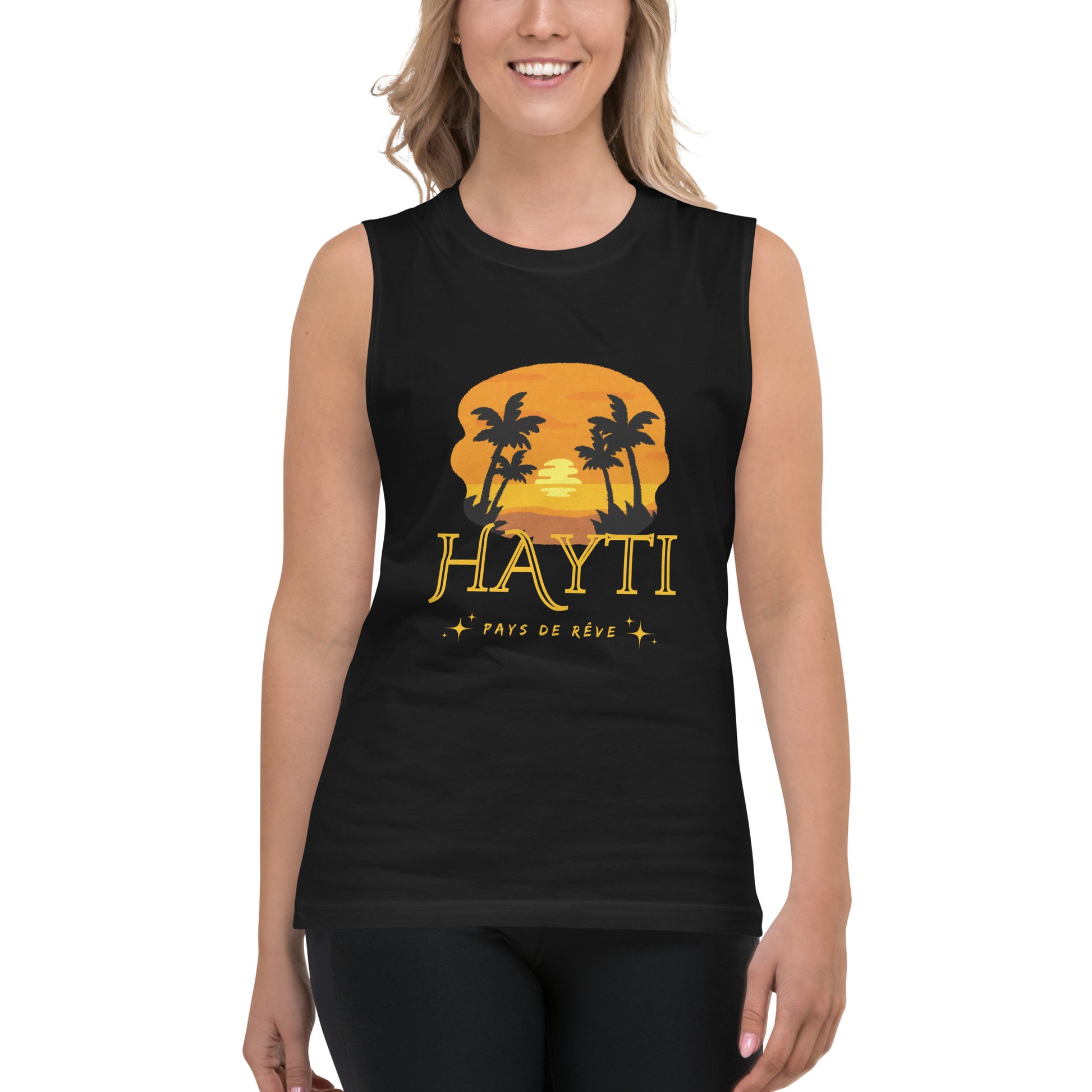 Female model wearing a black Bella+Canvas 'HAYTI PAYS DE RÊVE' unisex muscle tank top (front view) featuring a golden hour sunset graphic with palm trees and twinkling stars.