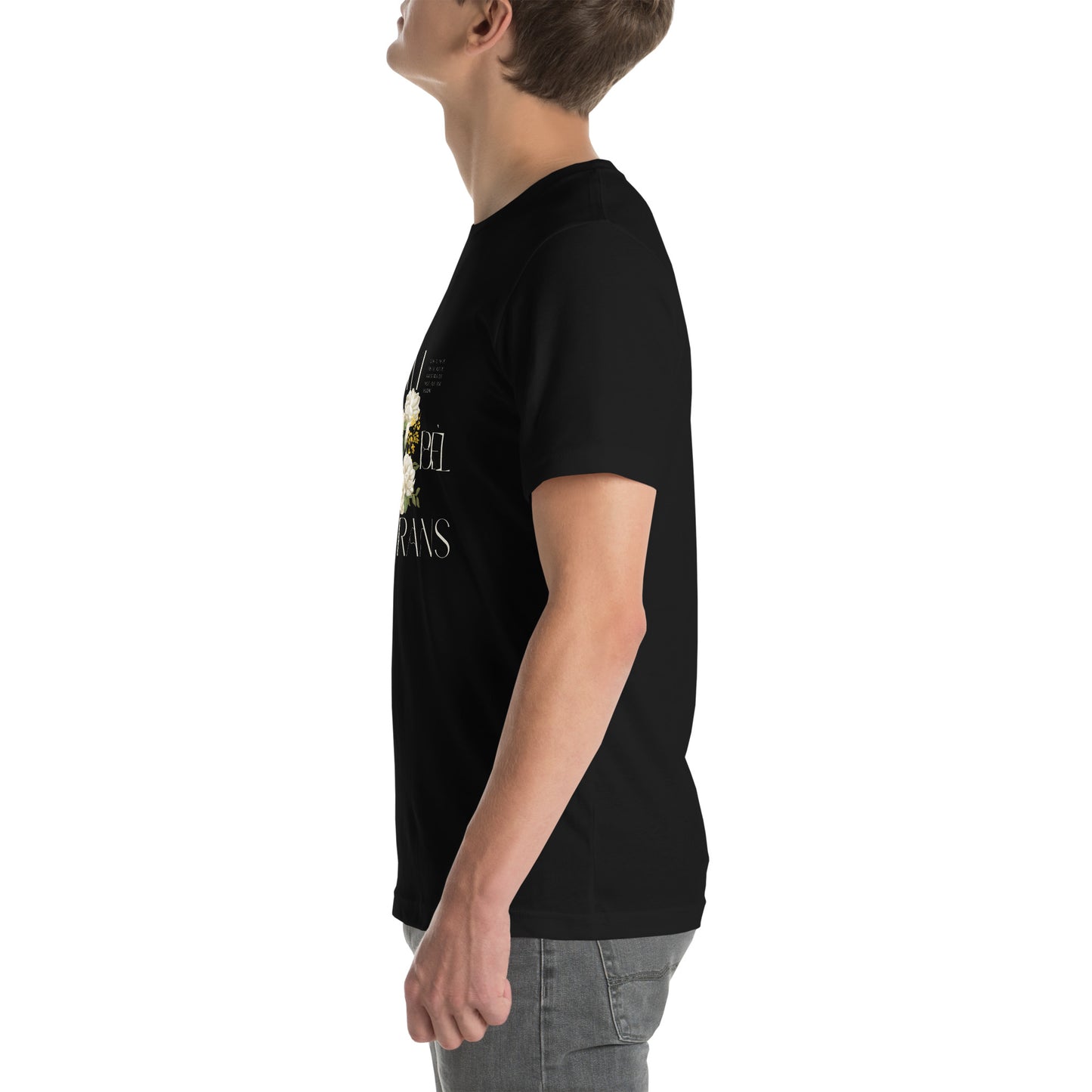 White Male model wearing a black Bella+Canvas 'LAVI S'ON BÈL RANS' unisex T-shirt (left side view) featuring cream text and a realistic white floral graphic