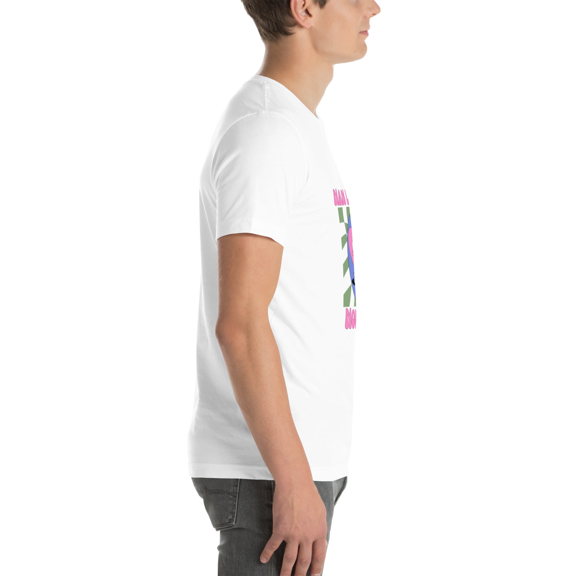 White man wearing a white Bella+Canvas 'Nan Lanmou Nou Kwe' unisex T-shirt (right side view) featuring a pink and blue abstract heart graphic with a smiley face and paint drip accents.